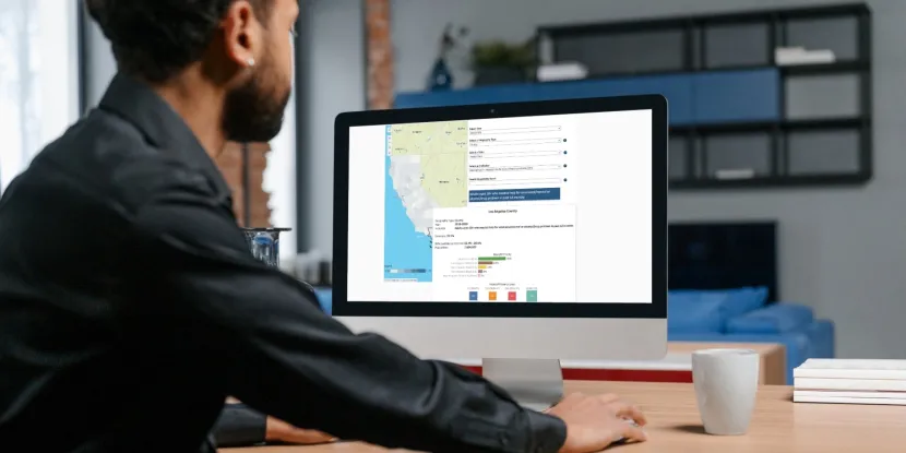 man at a computer looking at AskCHIS Neighborhood Edition with a map of California and bar charts