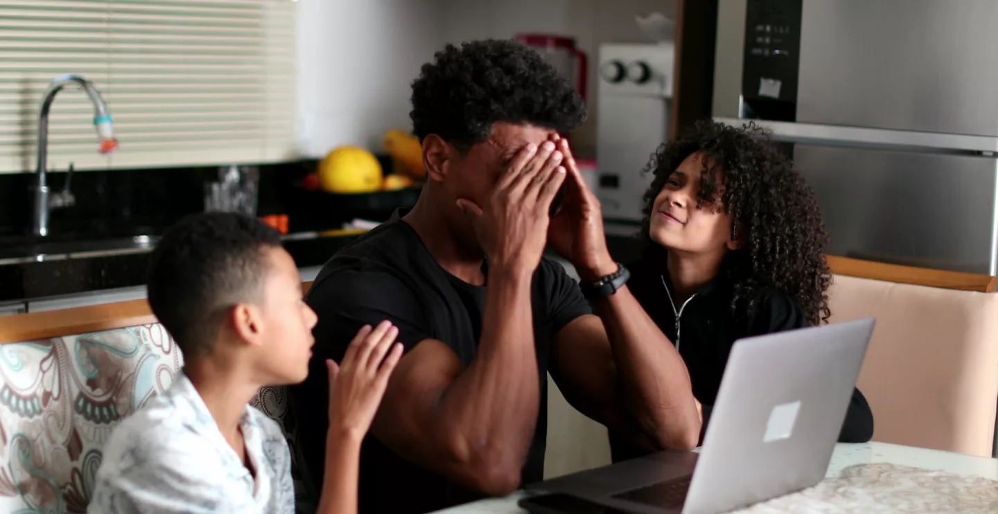 father struggling with two children by his side