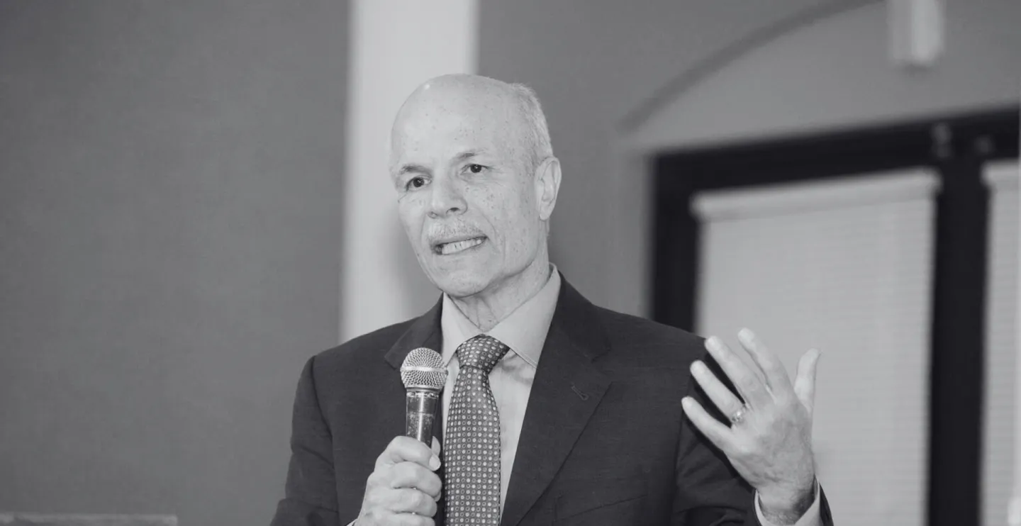 black and white photo of rick brown speaking into a microphone