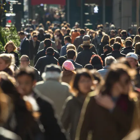 Crowd of anonymous people walking on busy New York City street