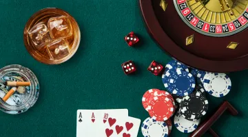 Overhead shot of playing cards, dice, casino chips and a roulette wheel